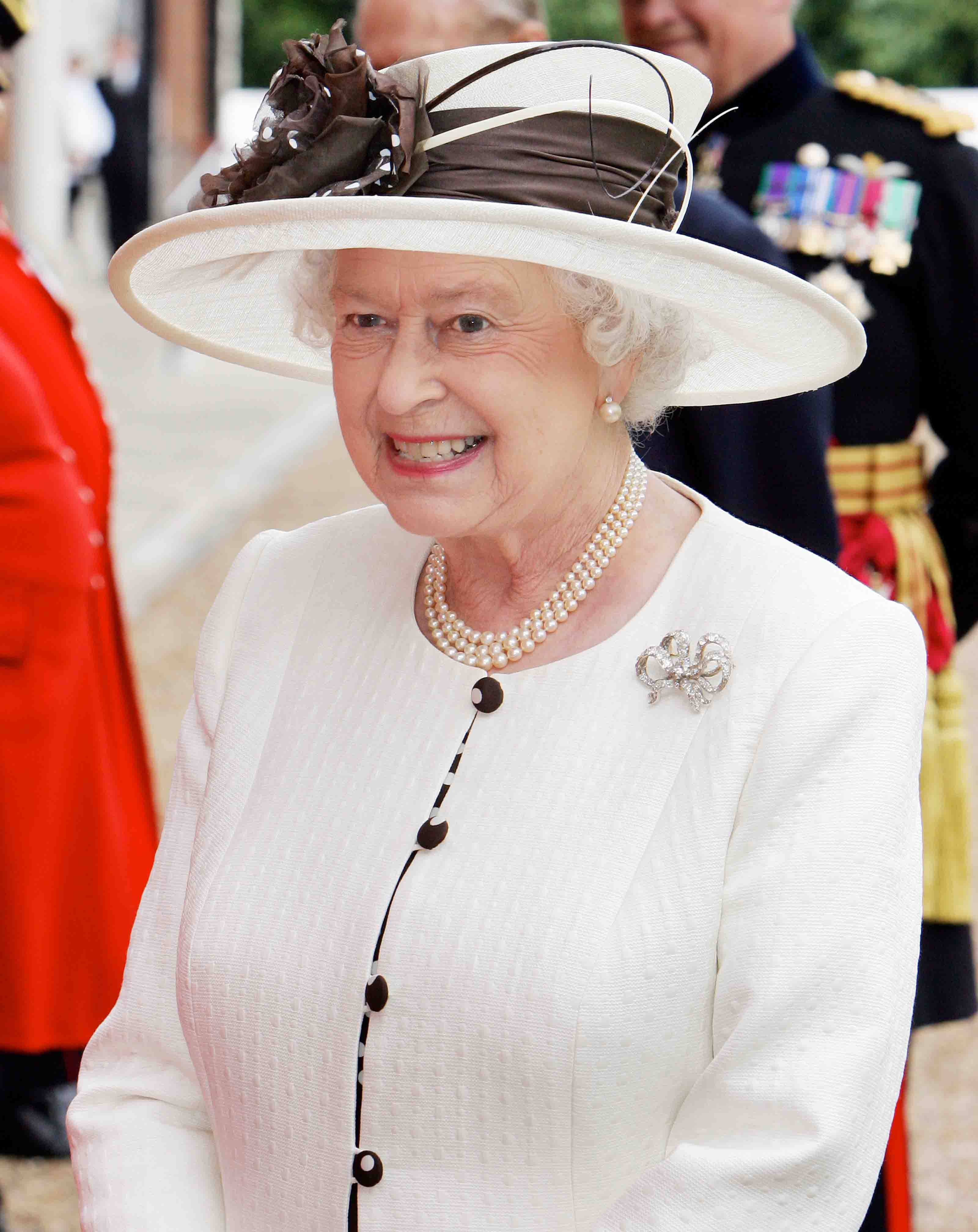 Her Majesty The Queen smiling and walking