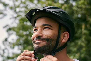 A man tightens his bicycle helmet