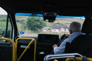 Community transport driver, driving an accessible mini-bus through rural Northern Ireland. 