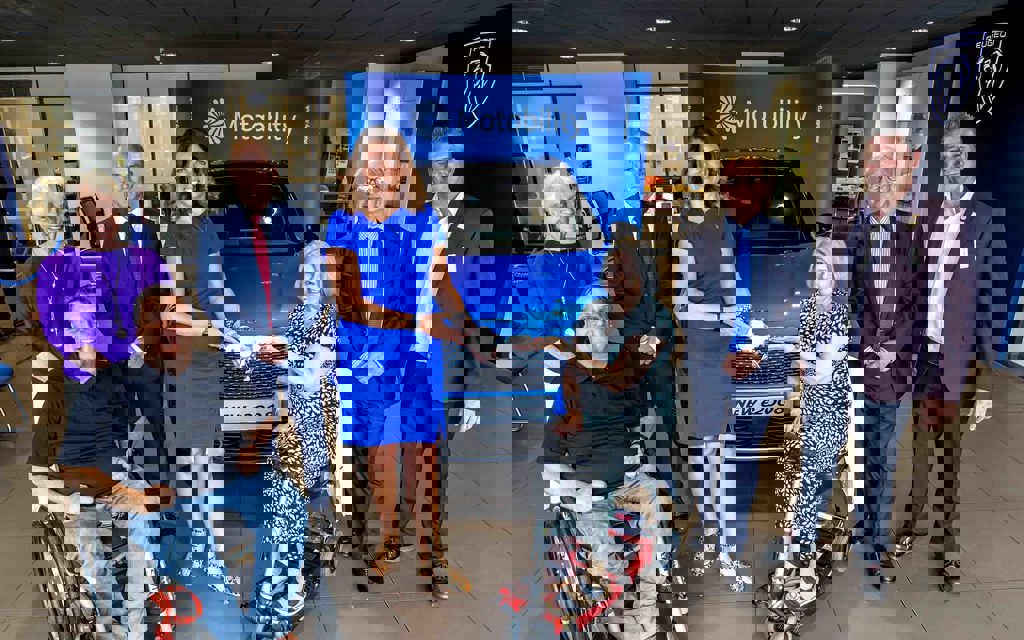 Caroline Nokes MP at Sue's car handover. Both are smiling in front of Sue's Peugeot e-2008 SUV.