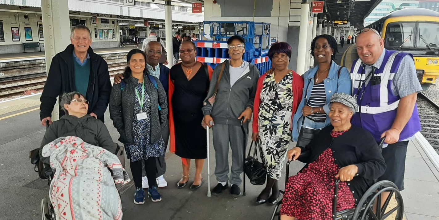 The photo from Severnside Community Rail Partnership shows ten people standing on a railway platform facing a camera and smiling.