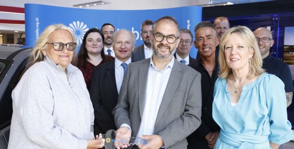 A photo of Paul Scully MP standing with Motability Scheme customer Louise. They are smiling and holding a large glass key.