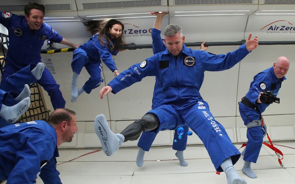 Photo of John and his team floating in the space craft.