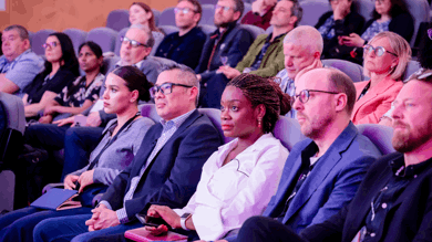 The photo is of a close-up on audience of attendees at the RNIB showcase event. The people pictured are sitting in cinema seats to watch Nyla's Journey short film.