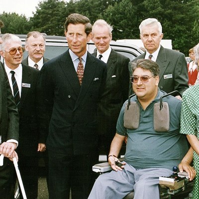 King Charles III presentation at the mobility roadshow 1993. King Charles III is smiling next to Motability Scheme customers. 