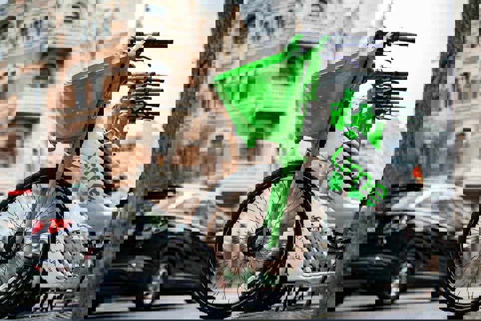 Image of a lined up Lime bikes on the street in a city.