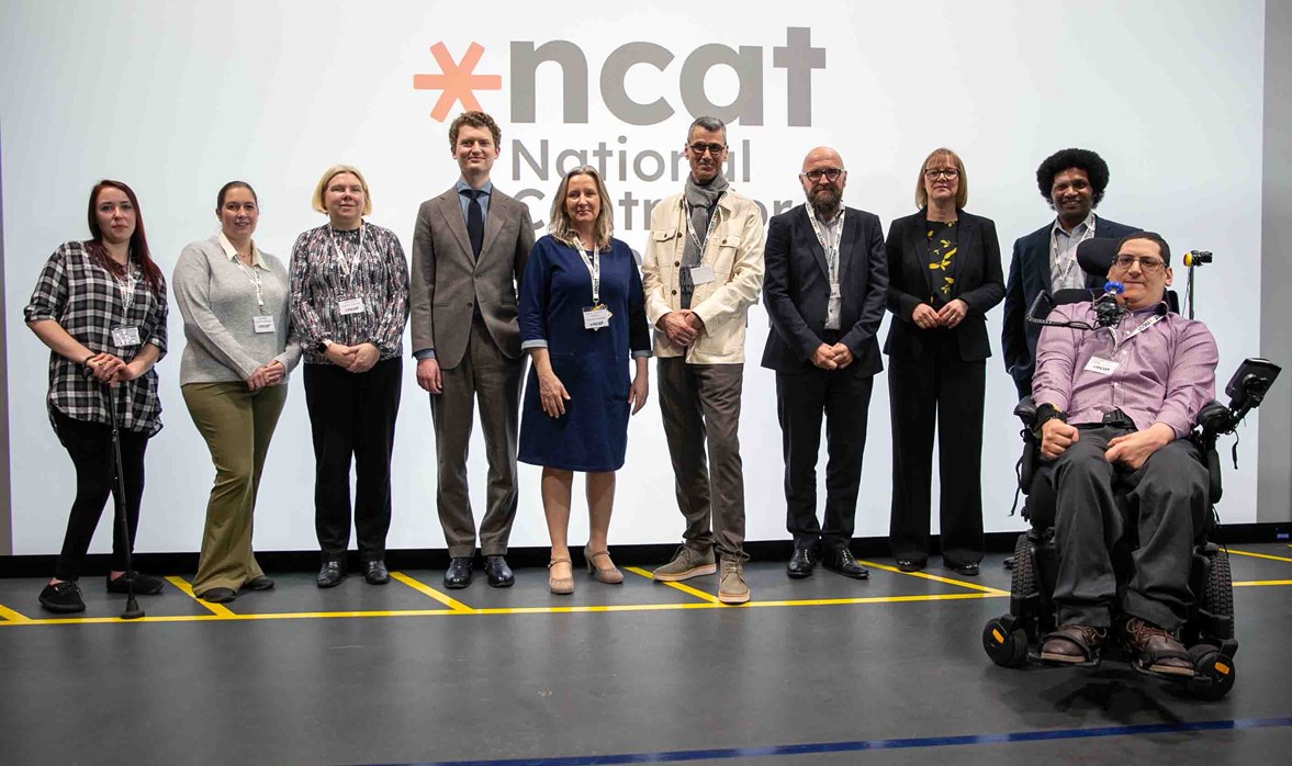 A group photo smiling in front of the NCAT logo which sits on a presentation backdrop. Caption left to right: Stephanie McPherson-Brown, Kay Atkin, Emily Nash, Robert McLaren, Cathryn Thompson-Goodwin, Professor Paul Herriotts, Gordon McCullough, Catharine Brown, Michael Edwards, Clive Gilbert 