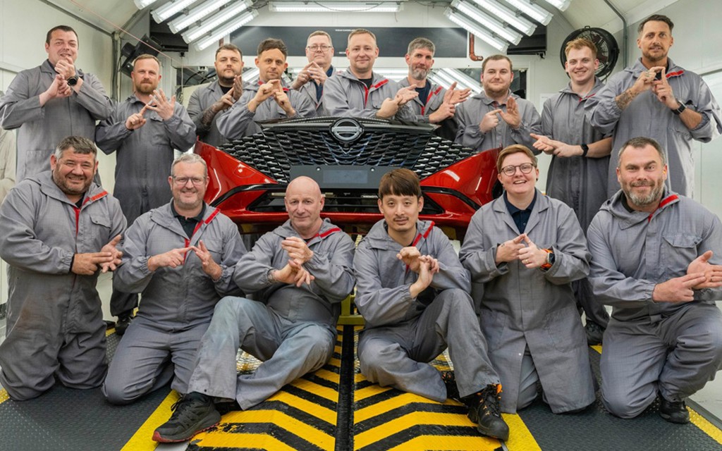 Nissan Sunderland Plant bumper paint team using British Sign Language gestures around a red car bumper.