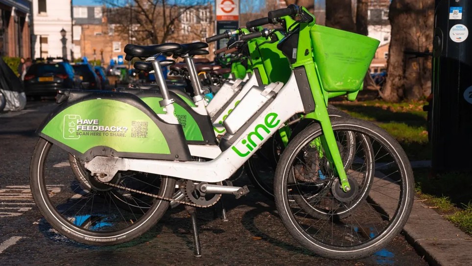A picture of Lime bikes parked on the side of the road together.