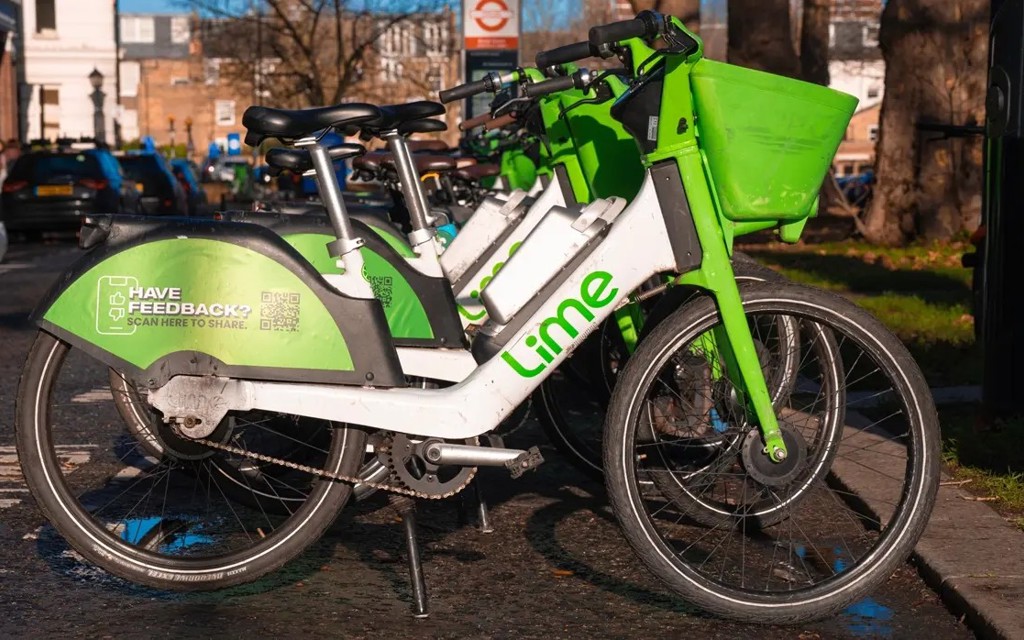 A picture of Lime bikes parked on the side of the road together.